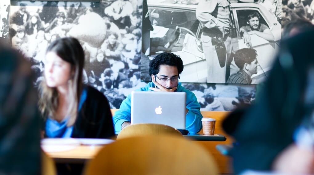 Student working on a Macbook at a cafe